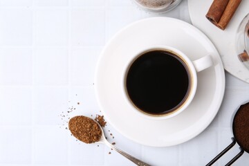 Cup of aromatic coffee and instant powder on white table, flat lay. Space for text