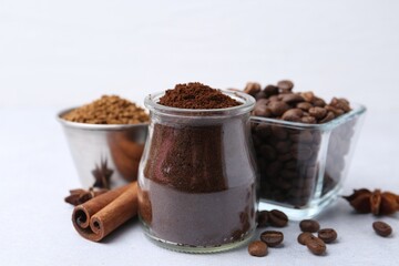 Different types of instant coffee, beans and spices on light table, closeup
