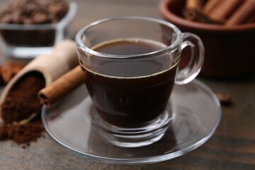 Refreshing coffee in cup on wooden table, closeup