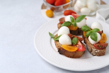Tasty sandwiches with mozzarella cheese, tomatoes and basil on white table, closeup. Space for text