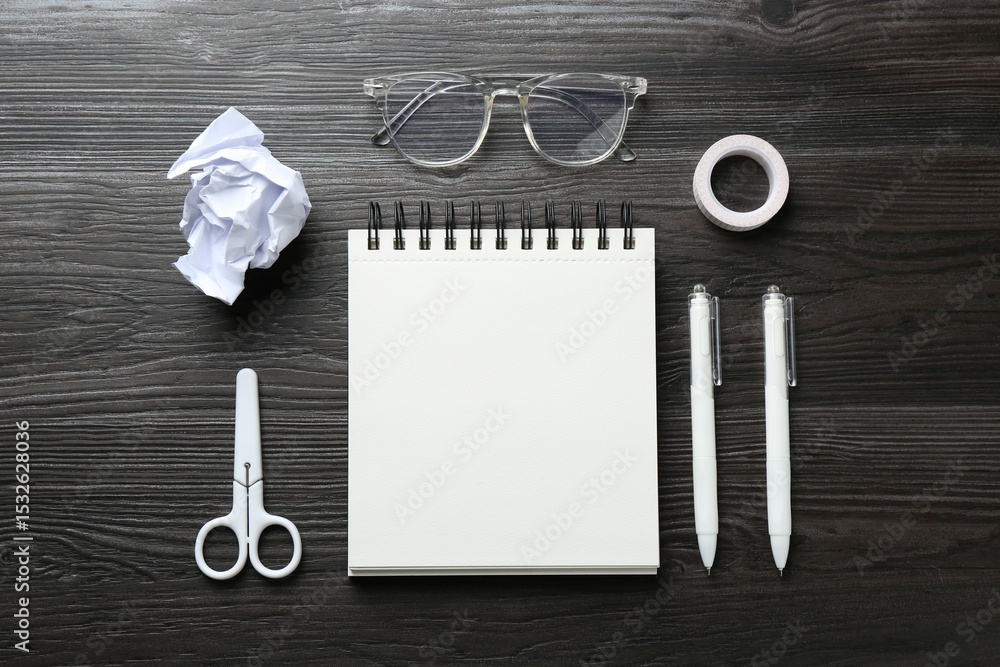 Poster flat lay composition with open blank notebook on black wooden table
