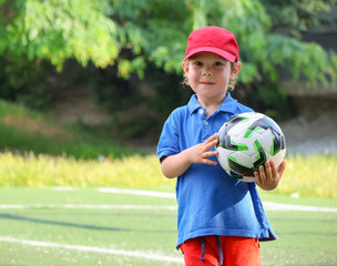  little three-year-old boy plays football at a sports school.