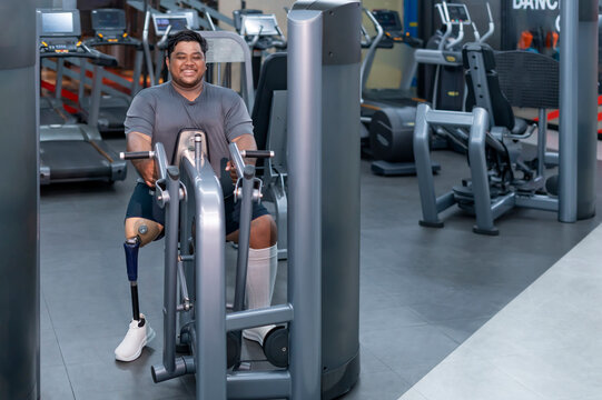 smiling obesity man,person with prosthetic leg doing sport training on fitness equipment,athlete,desire to lose weight,be strong,health and rehab