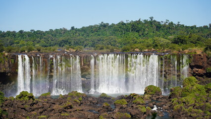 Stunning view of Iguazu Falls cascading through lush rainforest on the border of Brazil and Argentina, showcasing powerful waterfalls, mist, and vibrant natural beauty