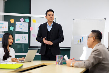 Presentation - Asian business man people giving presentation and Report pointing at white board. People Work in Business Office.