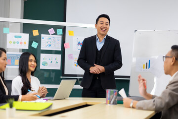 Presentation - Asian business man people giving presentation and Report pointing at white board. People Work in Business Office.