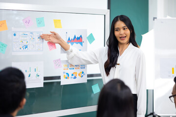 Presentation - Asian business woman people giving presentation and Report pointing at projector or TV screen. People Work in Business Office.