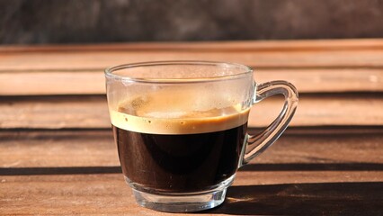 Shot of espresso coffee on wooden table.