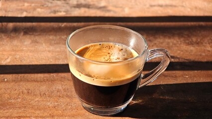 Shot of espresso coffee on wooden table.