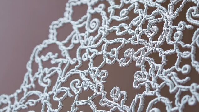 Delicate white lace floral pattern rotating slowly, revealing intricate embroidery details against warm brown backdrop