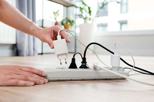Person is plugging in a device to a power strip