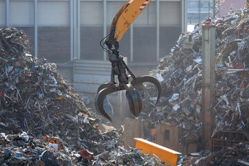Hydraulikkran hebt Altmetall auf dem Schrottplatz