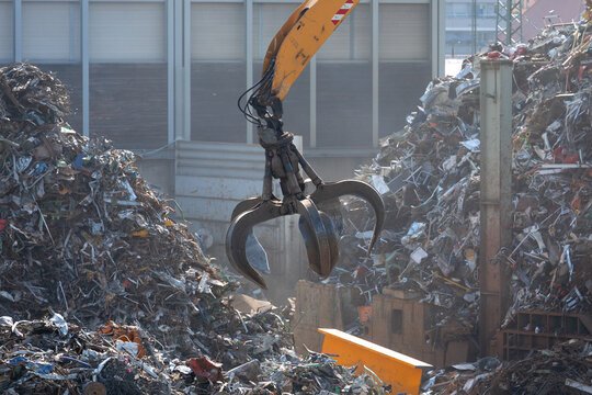 Hydraulikkran hebt Altmetall auf dem Schrottplatz