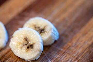 Selective focus on slices of a bananas on a wooden cutting board