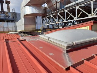 Vecchia copertura in lamiera coibentata e lucernario di un capannone industriale abbandonato con...