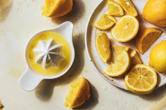 Juiced and sliced lemons with ceramic citrus juicer on table.jpg