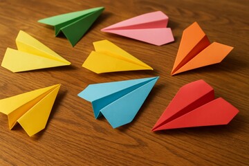 Colorful paper airplanes crafted from origami showcasing creativity and skill on a wooden table