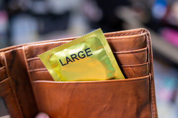 A large-sized condom in a leather wallet
