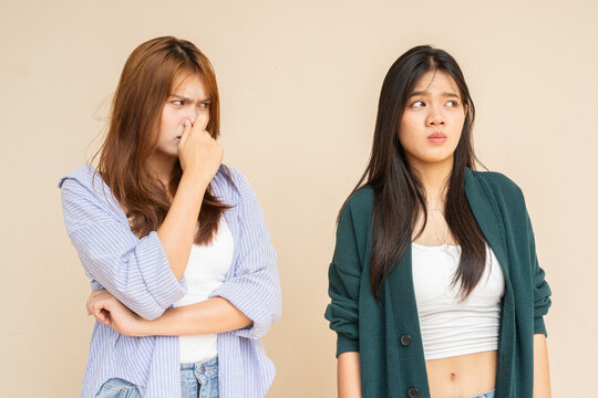 Woman covering her nose after her friend farted