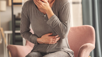 Young woman feeling nauseated at home