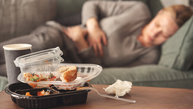 Woman with bloating and stomach pain after fast food meal