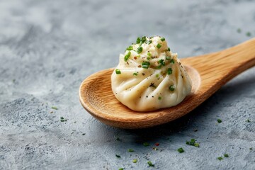 Single dumpling on a wooden spoon garnished with green onions and pepper