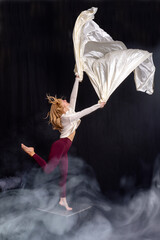 dancer; ballet; jump; pose; black outfit; grace; athleticism; dynamic movement; artistic expression.