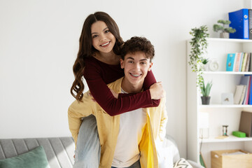 Teenage Boy Giving Piggyback Ride To Teenage Girl At Home