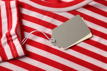 Cardboard tags on striped garment, top view