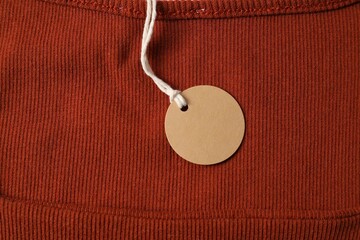 Cardboard tag on orange garment, top view