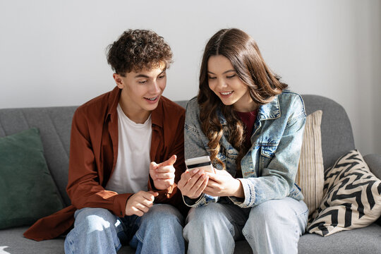 Young couple shopping online using credit card and smartphone at home - Powered by Adobe