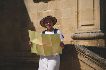 Woman Exploring Historic City Streets With a Map on a Sunny Day
