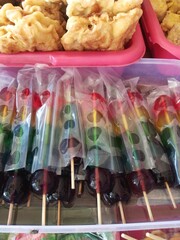Colorful Candied Fruit Skewers on Wooden Sticks at a Food Stall