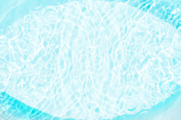 Blue water with ripples on the surface. Defocus blurred transparent blue colored clear calm water surface texture with splashes and bubbles. Water waves with shining pattern texture background.