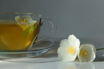 Cup of green tea with jasmine flowers