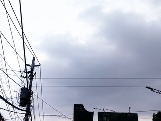 A suburban electric wire pole. Wires are tangled up on the power pole.