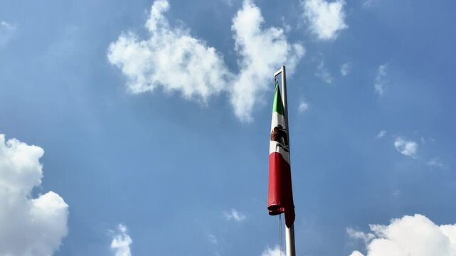 A flag is flying in the sky above a cloudy day