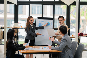 Group of Asian business people discussing charts and graphs showing the results of successful business investment and growth showing the results of successful teamwork.