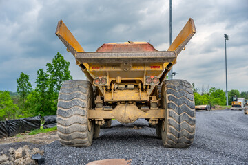 Obraz premium Back of an empty large industrial dump truck on a construction site. 