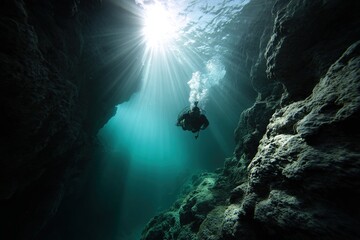 Diver explores underwater canyon with sunbeams illuminating rocky formations