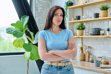 Portrait young smiling woman at home in kitchen