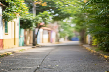 Defocused image of a quiet Urban Street Lined with Trees and Colorful Houses, Suggesting Peace, Simplicity, and Everyday Life in a Sunny Neighborhood. To be used as background
