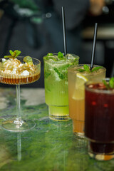 Four refreshing cocktails served at a stylish bar during an evening gathering