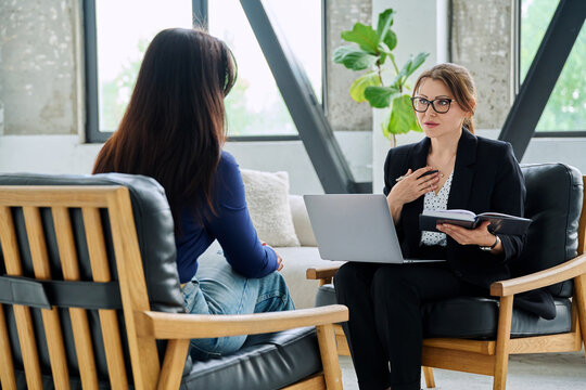 Female journalist, employer interviewing working with woman sitting together in office