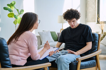 Young male patient talking to professional psychologist social worker counselor