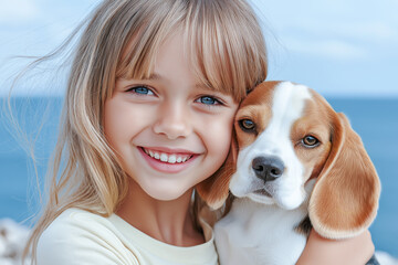 Girl happy smiling 5-7 years old in yellow T-shirt on the background of the blue sea hugs a puppy beagle breed