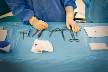 Nurse sitting on the table of an instrumentalist in a dermatology operating room