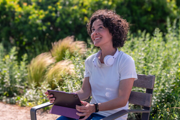 Digital nomad enjoying outdoor work with tablet and headphones