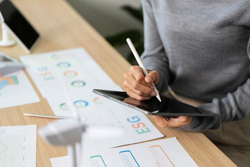 ESG Focused Discussion. Professional Analyzing Data on Tablet in Modern Office.