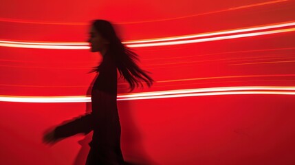 Silhouette of a woman in motion against red backdrop.